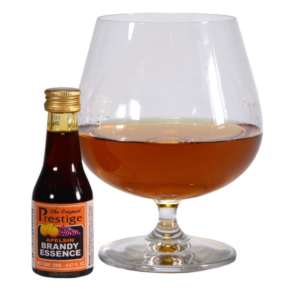 Szklana buteleczka 20 ml zaprawki do alkoholu Prestige Brandy Apelsin z pomarańczowo-złotą etykietą na białym tle, obok zaprawki kieliszek z nalaną brandy.